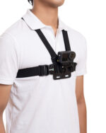 Person in a white shirt wearing a black chest-mounted action camera rig with straps.