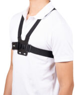 Black torso harness with buckles worn over a white shirt (upper chest and shoulders visible).