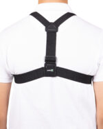 Back view of a person wearing black cross-back suspenders over a white shirt with a rectangular clip at the center of the back.
