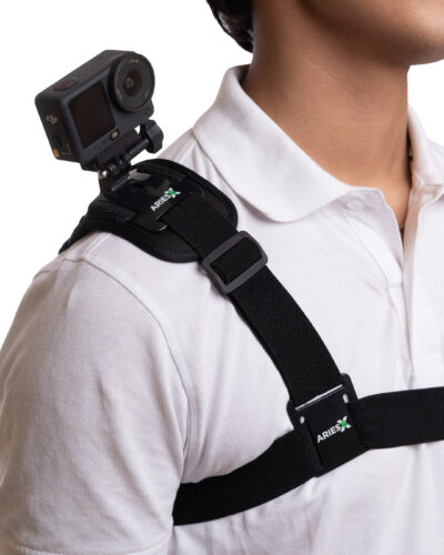 Close-up of a person wearing a black chest mount with an action camera attached, ARIES logo on the strap, white shirt visible.