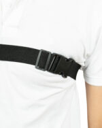 Close-up of a person wearing a white shirt with a black belt around the waist.
