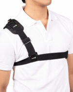 Person wearing a black shoulder strap with an Aries logo across a white shirt.