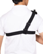 Back view of a person wearing a white shirt with a black crossbody strap and buckle across the chest.