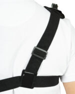 Close-up of a black shoulder strap with a buckle crossing a white shirted torso