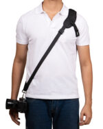 Person wearing a white polo shirt with a black camera on a strap diagonally across the chest, hanging at the hip
