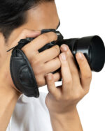 Person holding a camera up to their face, ready to shoot; lens with hood attached (Sony branding visible)